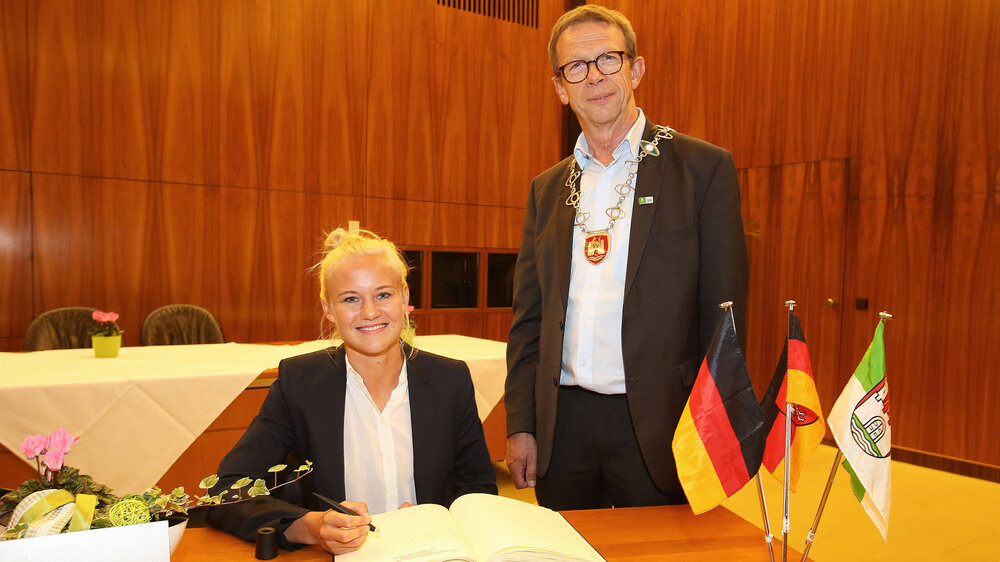 Pernille Harder unterschreibt im goldenen Buch der Stadt, neben ihr Oberbürgermeister Klaus Mohrs.