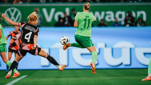 VfL-Wolfsburg-Spielerin Alexandra Popp springt in die Luft und trifft den Ball mit ihrer Hacke des linken Fuß.