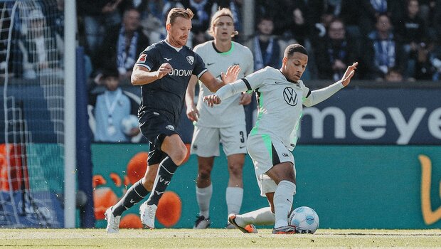 VfL-Wolfsburg-Spieler Aster Vranckx im Zweikampf mit einem Gegenspieler.
