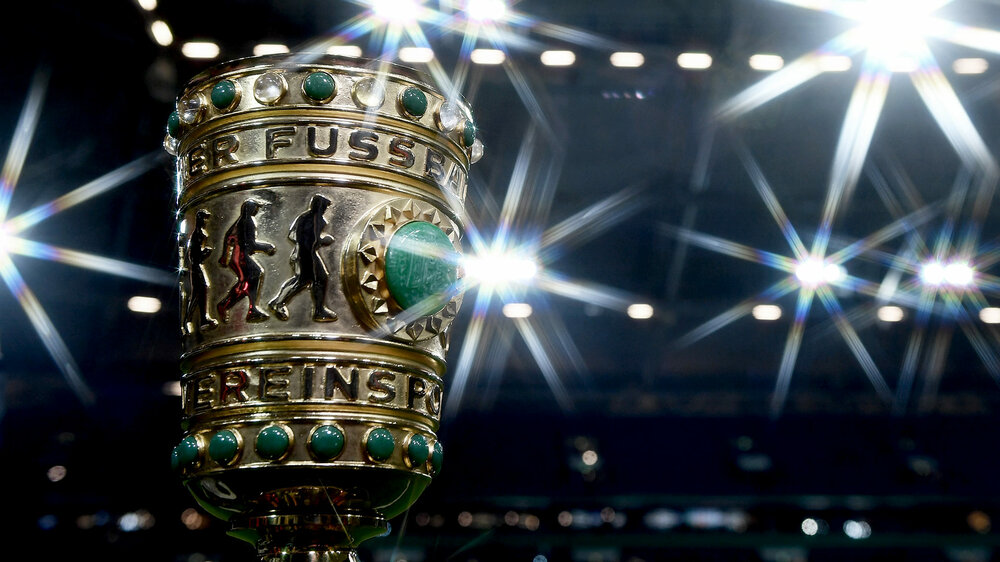 Nahaufnahme des DFB Pokals vor Lichtern im Stadion. 