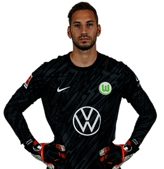 Der VfL Wolfsburg Spieler Niklas Klinger posiert mit den Händen in der Hüfte.