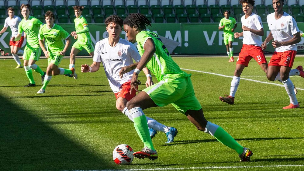Ein Spieler der U19-Mannschaft des VfL Wolfsburg setzt sich im Zweikampf gegen einen Gegenspieler durch.