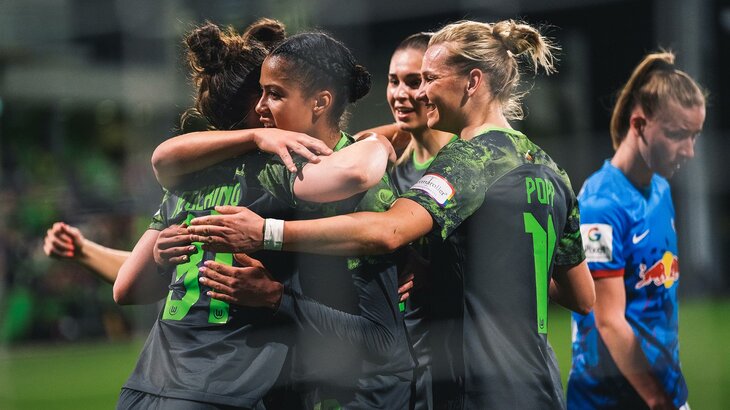 Die Spielerinnen des VfL Wolfsburg umarmen sich und jubeln.