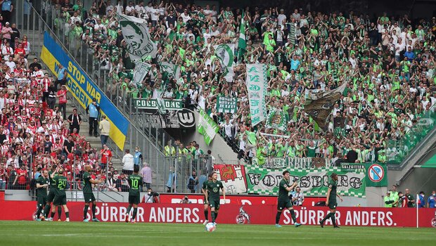 Die Spieler des VfL Wolfsburg stehen vor ihrer Fankurve und klatschen.
