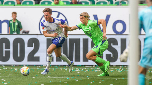 VfL Wolfsburg Spieler Bornauw sprintet im Duell mit einem Gegner dem Ball hinterher.