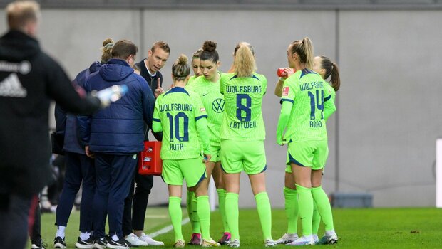 Die Spielerinnen des VfL Wolfsburg besprechen sich mit Trainer Tommy Stroot.