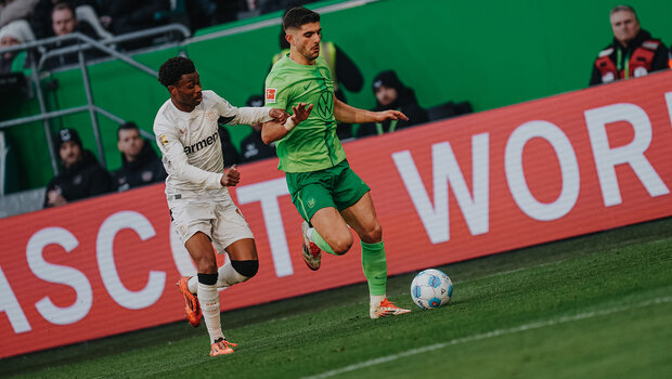 VfL-Wolfsburg-Spieler Konstantinos Koulierakis im Zweikampf mit einem Gegenspieler.
