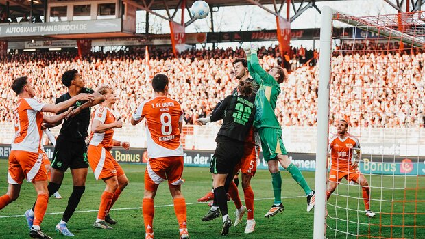 VfL-Wolfsburg-Spieler Jonas springt im gegnerischen Strafraum für einen Kopfball in die Höhe. Um ihn herum sind einige VfL- Und Union-Spieler.