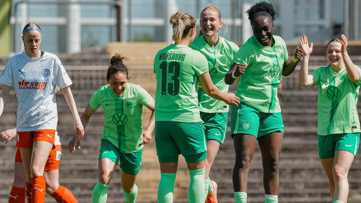 Spielerinnen des U20-Teams des VfL Wolfsburg stehen beisammen und springen, lachen und klatschen sich ab.