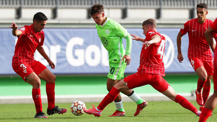 Ein U19 Spieler des VfL Wolfsburg im Kampf um den Ball mit 3 Gegenspielern aus Sevilla.