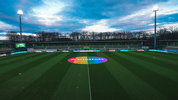 Ein Banner in Regenbogenfarben mit dem Schriftzug "Vielfalt" liegt auf dem Mittelkreis im AOK Stadion des VfL Wolfsburg.