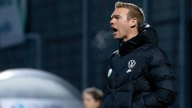 VfL-Wolfsburg-Trainer Tommy Stroot coacht seine Mannschaft vom Seitenrand.