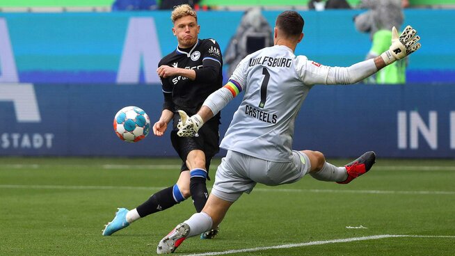 Torhüter Koen Casteels in voller Aktion vor dem Tor. Er macht sich lang, um den Ball abzuwehren.