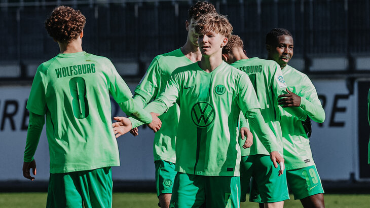 Spieler der VfL Wolfsburg u17 jubeln gemeinsam auf dem Fußballplatz.