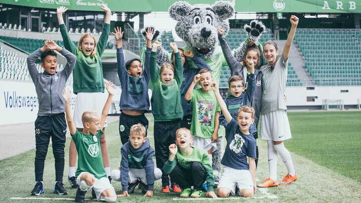 Das Maskottchen des VfL Wolfsburg zusammen mit Kindern in der Volkswagen Arena.