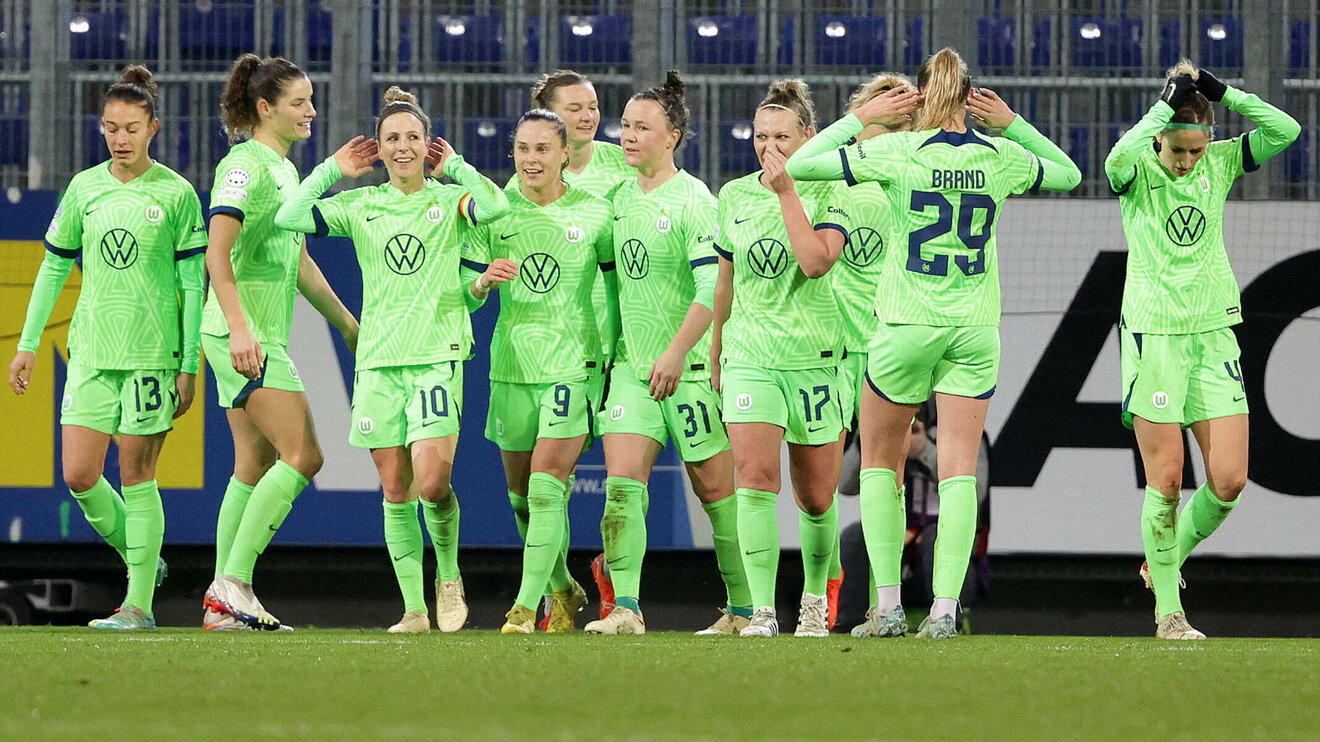 Die Spielerinnen vom VfL Wolfsburg jubeln nach einem Tor.