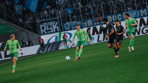 VfL-Wolfsburg-Spieler Andreas Skov Olsen spielt einen Pass zu einem Mitspieler.