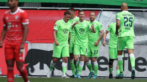 Gerhardt, Kruse, Arnold und weitere Wölfe feiern ein Tor des VfL Wolfsburg gegen Bayern München, Gerhardt zeigt mit beiden Händen lächelnd auf den auf ihn zulaufenden Brooks.