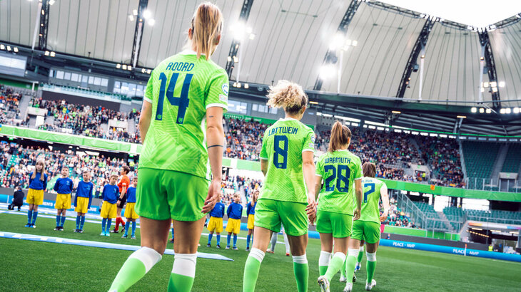 VfL Wolfsburg Spielerinnen Roord, Lattwein und Wassmuth laufen in die Volkswagen Arena ein, das Foto zeigt alle Damen von hinten hintereinander laufend