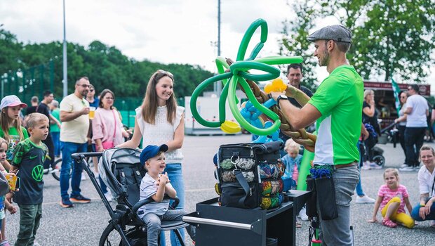Kind freut sich über ein Luftballontier beim Familienfest des VfL Wolfsburg.