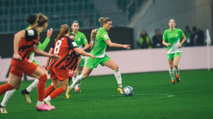 Alexandra Popp, die Kapitänin vom VfL Wolfsburg, läuft mit dem Ball voraus und die Frankfurterinnen ziehen nach.