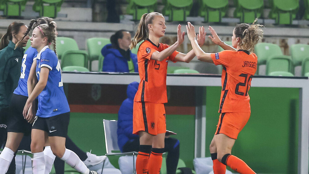Die VfL-Wolfsburg-Spielerinnen Jill Roord und Dominique Janssen klatschen bei einer Auswechselung ab im Trikot der niederländischen Nationalmannschaft.