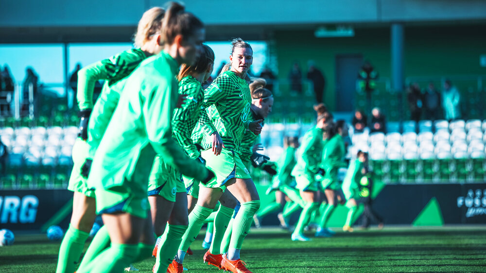 Die Spielerinnen des VfL Wolfsburg laufen sich vor dem Spiel warm.