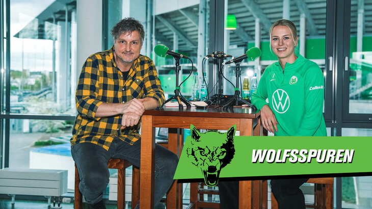 Die VfL-Wolfsburg-Spielerin Merle Frohms sitzt mit einem Moderator hinter Mikrofonen.