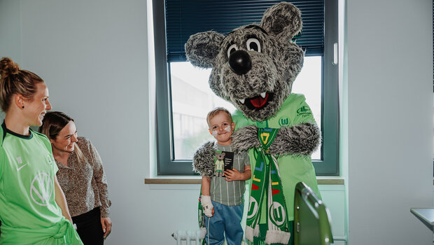 Wölfi macht ein Foto mit einem Kind im Krankenhaus.