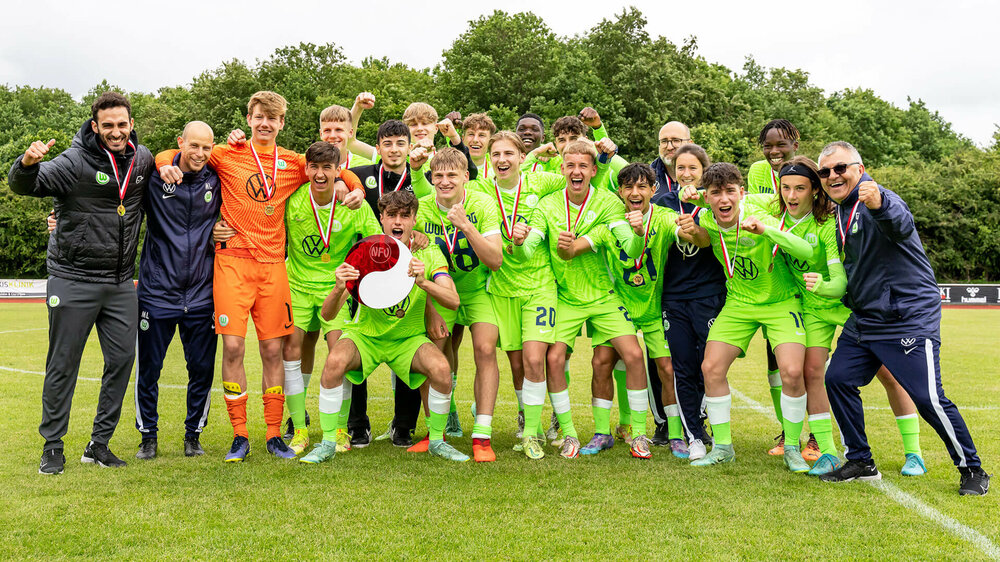 Die U16-Junioren des VfL Wolfsburg jubeln gemeinsam mit ihren Trainern.