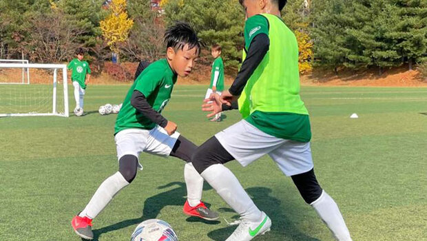 Kinder spielen Fußball in der Fußballschule des VfL Wolfsburg in Korea.