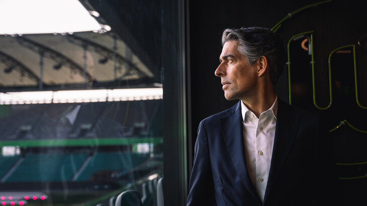 VfL-Wolfsburg-Geschäftsführer Michael Meeske schaut aus dem Fenster in die Volkswagenarena.