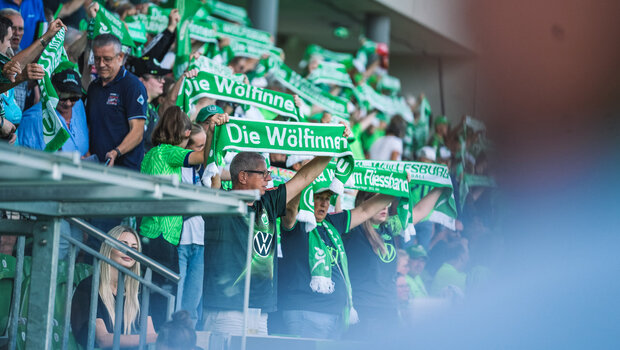 Die Fans der Wölfinnen halten die VfL Wolfsburg-Schals in die Luft.