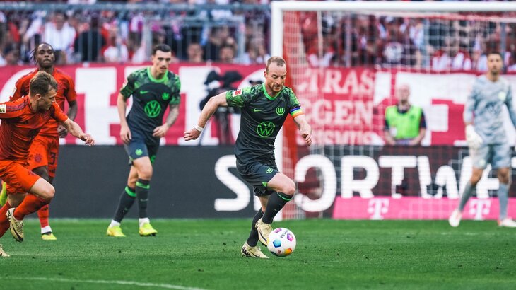 VfL-Wolfsburg-Spieler Maximilian Arnold mit dem Ball am Fuß gegen Spieler des FC Bayern München.