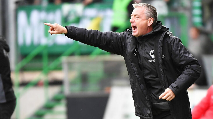 Der neue VfL-Wolfsburg-Akademie-Trainer Rainer Widmayer zeigt auf das Spielfeld.