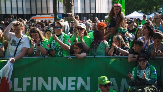 Die Fans des VfL Wolfsburg bejubeln die Frauenmannschaft auf der Bühne. 