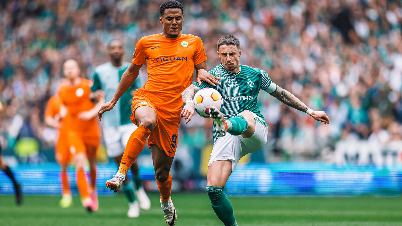 VfL Wolfsburg Spieler Amin Sarr im Zweikampf um den Ball mit einem Gegenspieler aus Bremen.