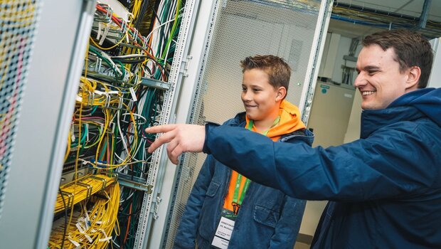 Einem Jungen wird beim Zukunftstag des VfL Wolfsburg der Technikraum gezeigt.