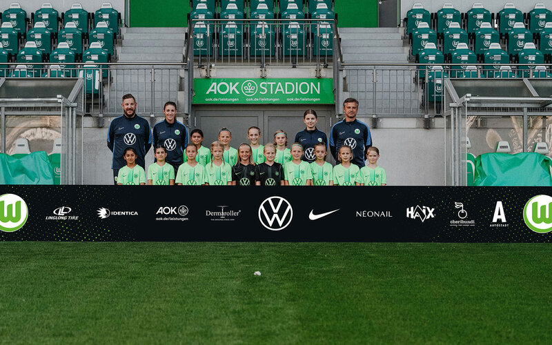 Das Juniorinnen Talentteam des VfL Wolfsburg posiert für ein Mannschaftsfoto.