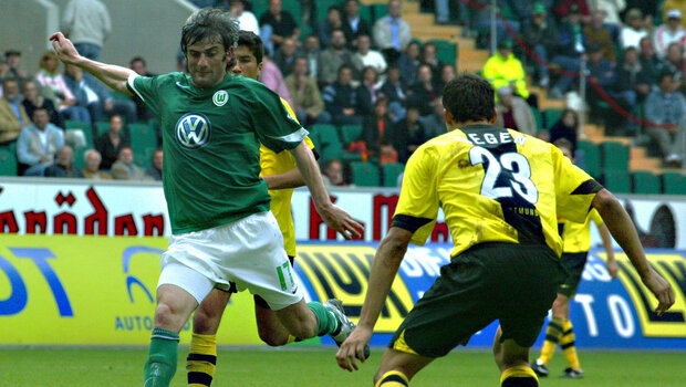 Spielsituation bei der ein VfL-Spieler mit dem linken Fuß den Ball spielt. Von vorne stellt sich ihm ein BVB-Spieler in den Weg.