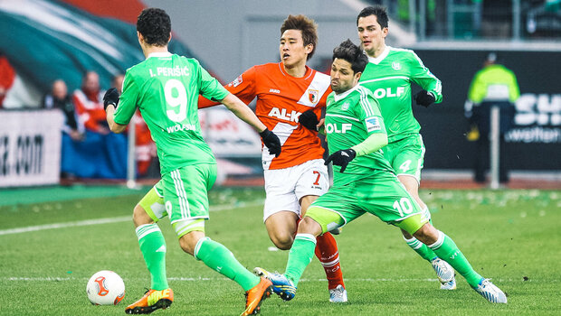 Historisches Foto von VfL Wolfsburg Spielern im Kampf um den Ball mit einem Gegner aus Augsburg.