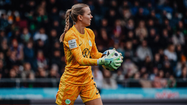 VfL-Wolfsburg-Spielerin Merle Frohms hält den Ball in der Hand.