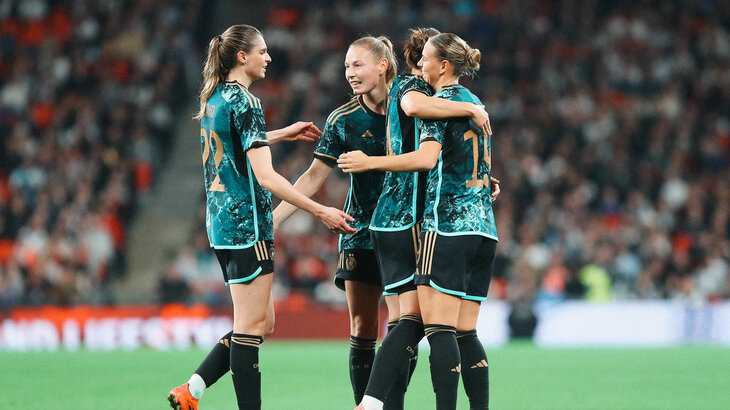VfL Wolfsburg Spielerinnen Jule Brand und Sarai Linder jubeln gemeinsam mit Spielkameradinnen im Trikot der deutschen Nationalmannschaft.