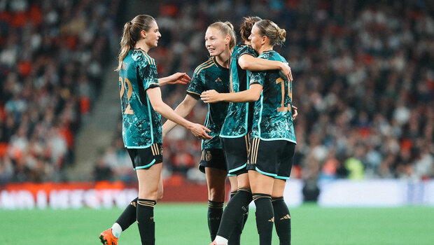 VfL Wolfsburg Spielerinnen Jule Brand und Sarai Linder jubeln gemeinsam mit Spielkameradinnen im Trikot der deutschen Nationalmannschaft.