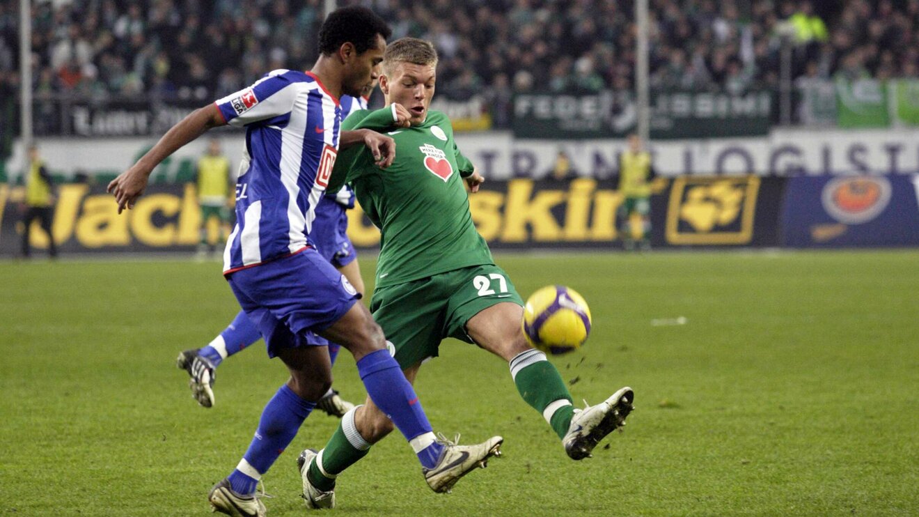 Der ehemalige Spieler des VfL Wolfsburg Alexander Esswein kämpft auf dem Spielfeld mit einem Gegner um den Ball.