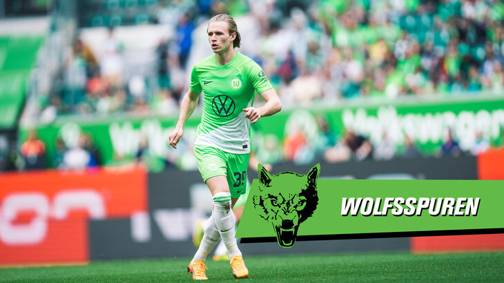 Patrick Wimmer läuft über den Platz. Davor liegt eine VfL-Wolfsburg-Grafik mit der Aufschrift "Wolfsspuren".