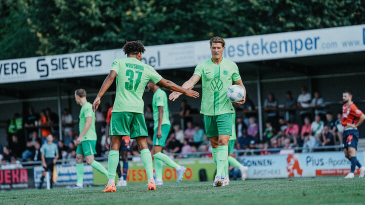 VfL Wolfsburg Spieler Kevin Behrens klatscht sich mit einem Mitspieler ab beim Testspiel gegen Lille OSC.