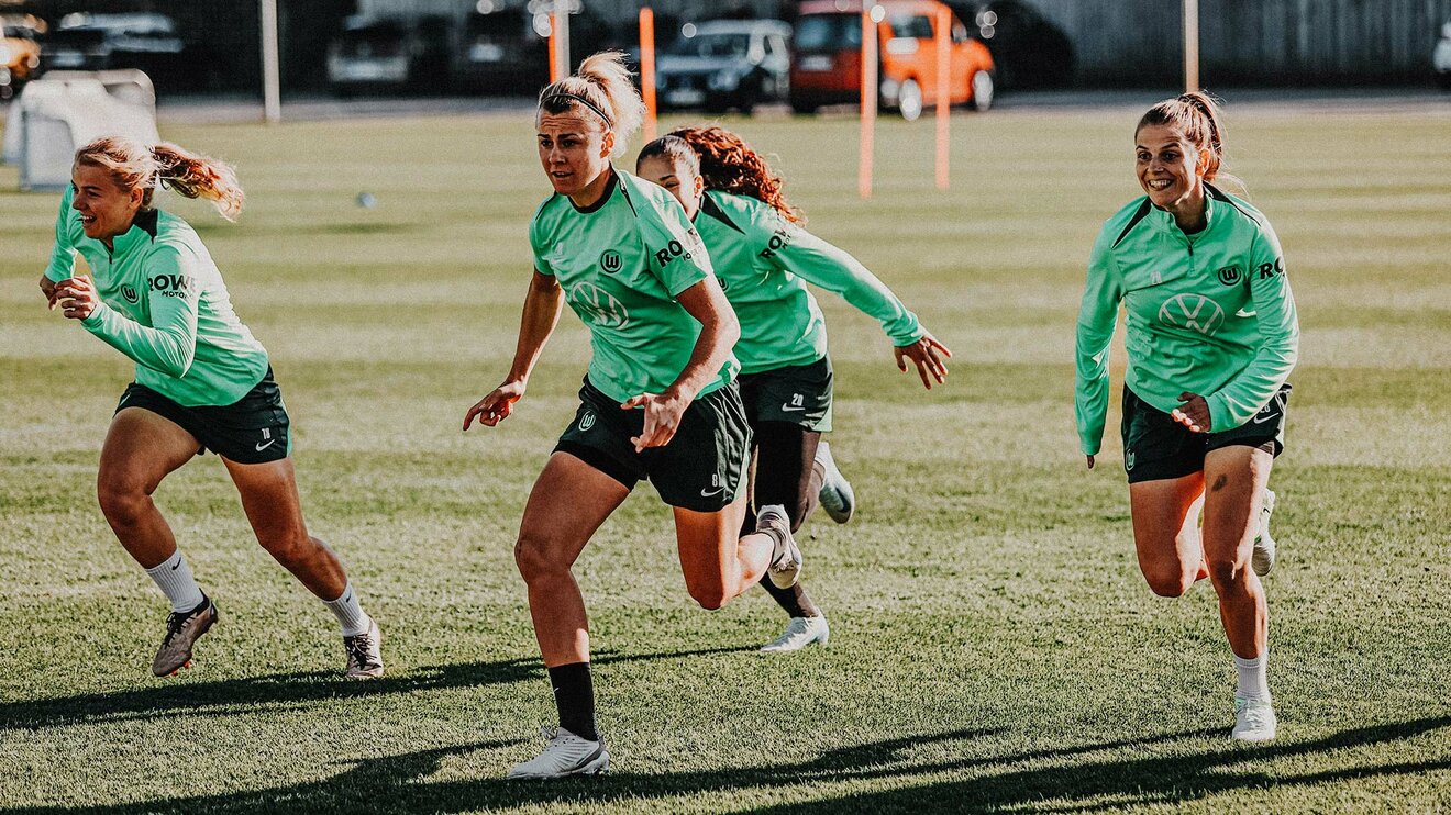 VfL-Wolfsburg-Spielerin Lena Lattwein rennt mit drei ihrer Mitspielerinnen auf dem Trainingsplatz.