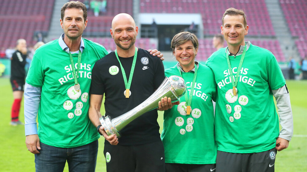 Trainer Stephan Lerch hält den DFB-Pokal in den Händen und neben ihm stehen von links: Ralf Kellermann, Ariane Hingst und Torwarttrainer Patrick Platins.