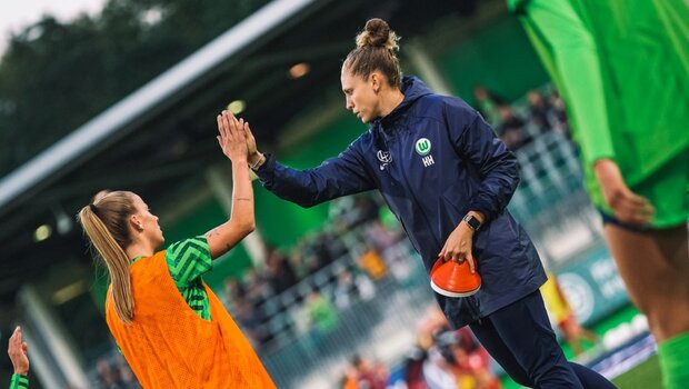 Trainerin der Frauen des VfL Wolfsburg, Kim Kulig, klatscht mit Lynn Wilms ein.